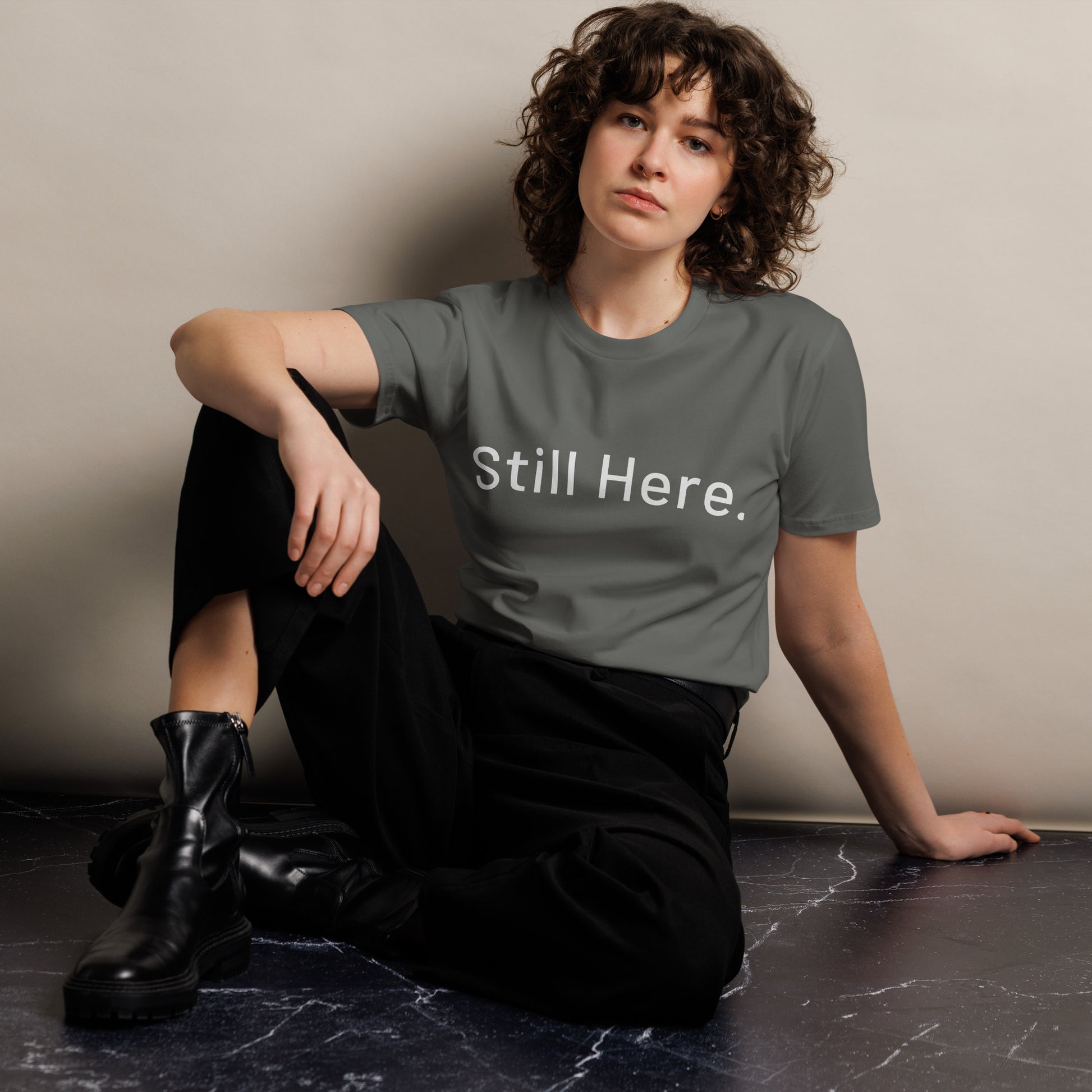 Still Here Co. charcoal tee front view — minimalist resilience apparel
